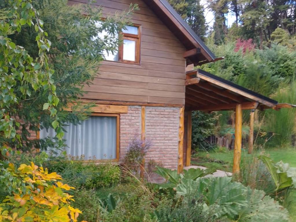 Cabaña de madera de dos plantas con galería