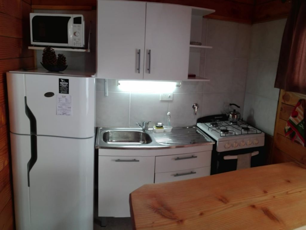 Cocina con horno, bacha y mesa de madera