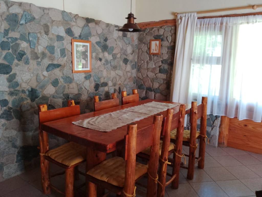 Comedor con pared de piedra y mesa de madera